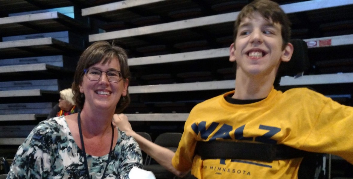 Middle-aged mom and 19-year old son seated in wheelchair smiling