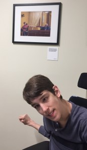 Justin in front of framed photo of him and Senator Durenberger
