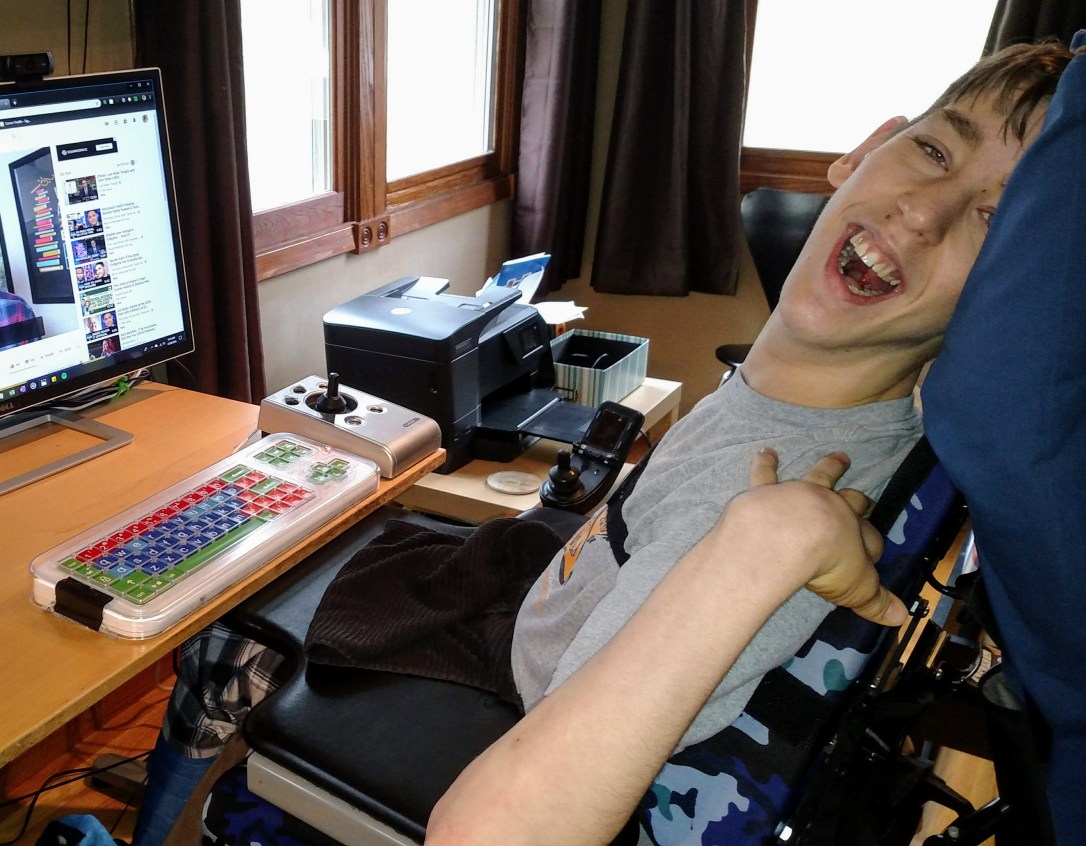 Justin sitting in wheelchair by computer