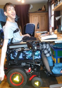 Justin sitting in wheelchair with casts on legs
