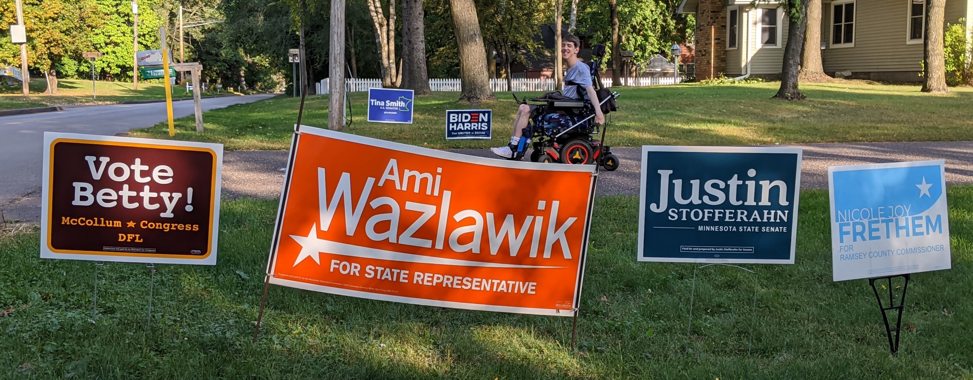 Justin smiling looking at political candidate signs in yard