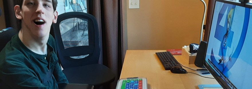 Justin with hand on joystick mouse at computer