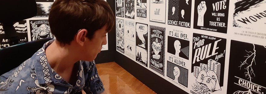 Justin looking at Piotr Szyhalski art exhibit black and white prints