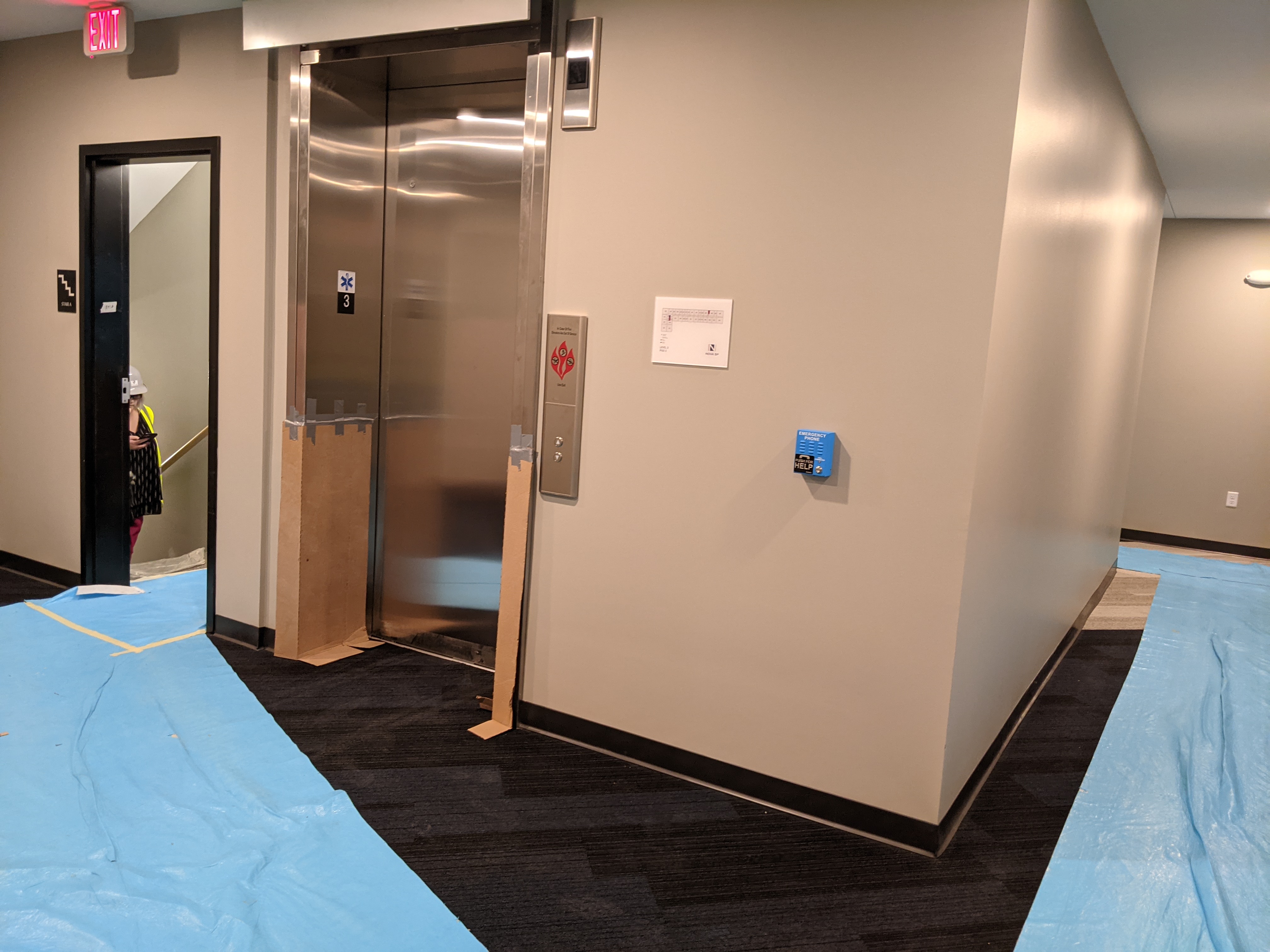Elevator, blue paper on floors, inside of a building