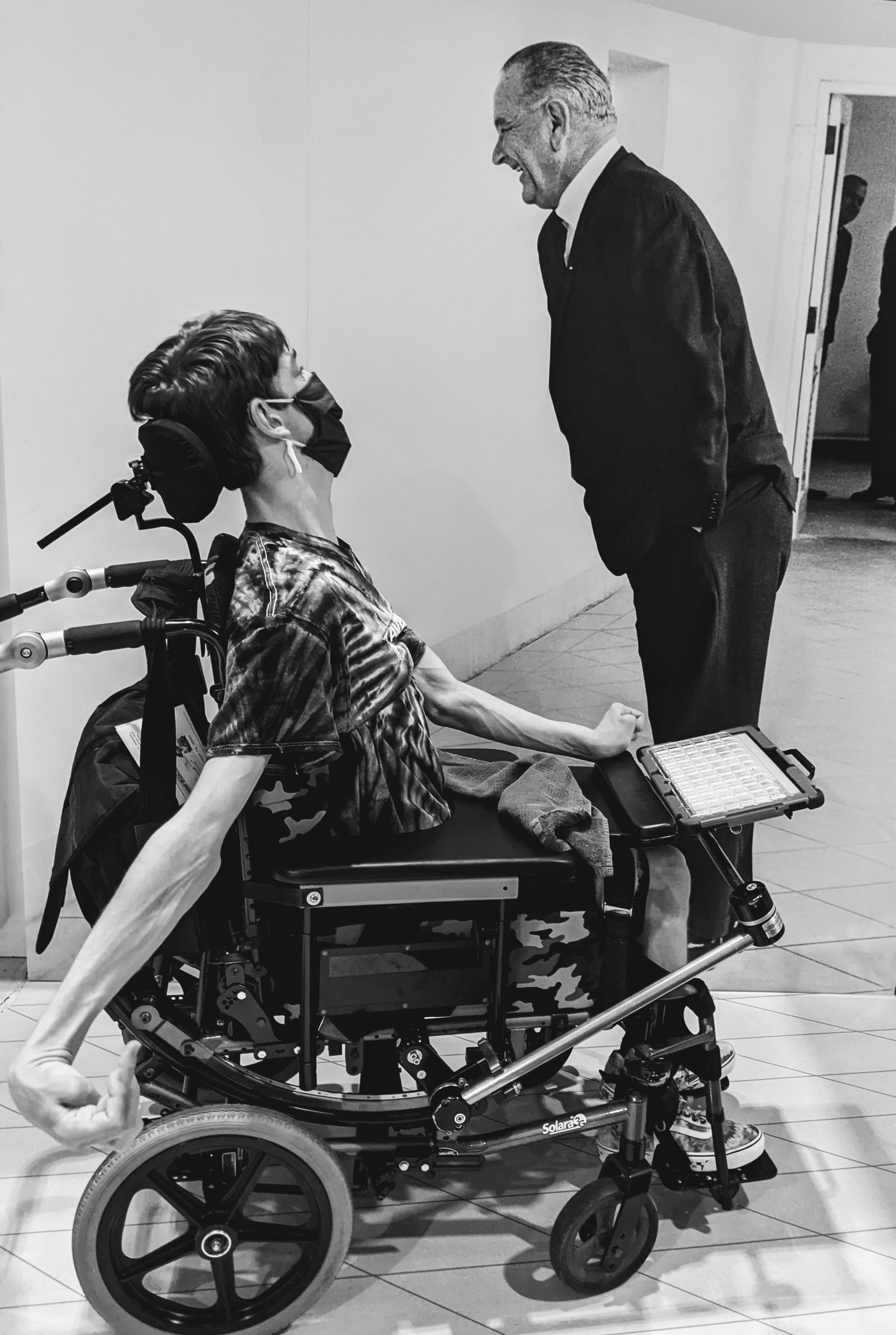 Black and white photo of Justin looking up at life-size photo of President Lyndon Johnson 
