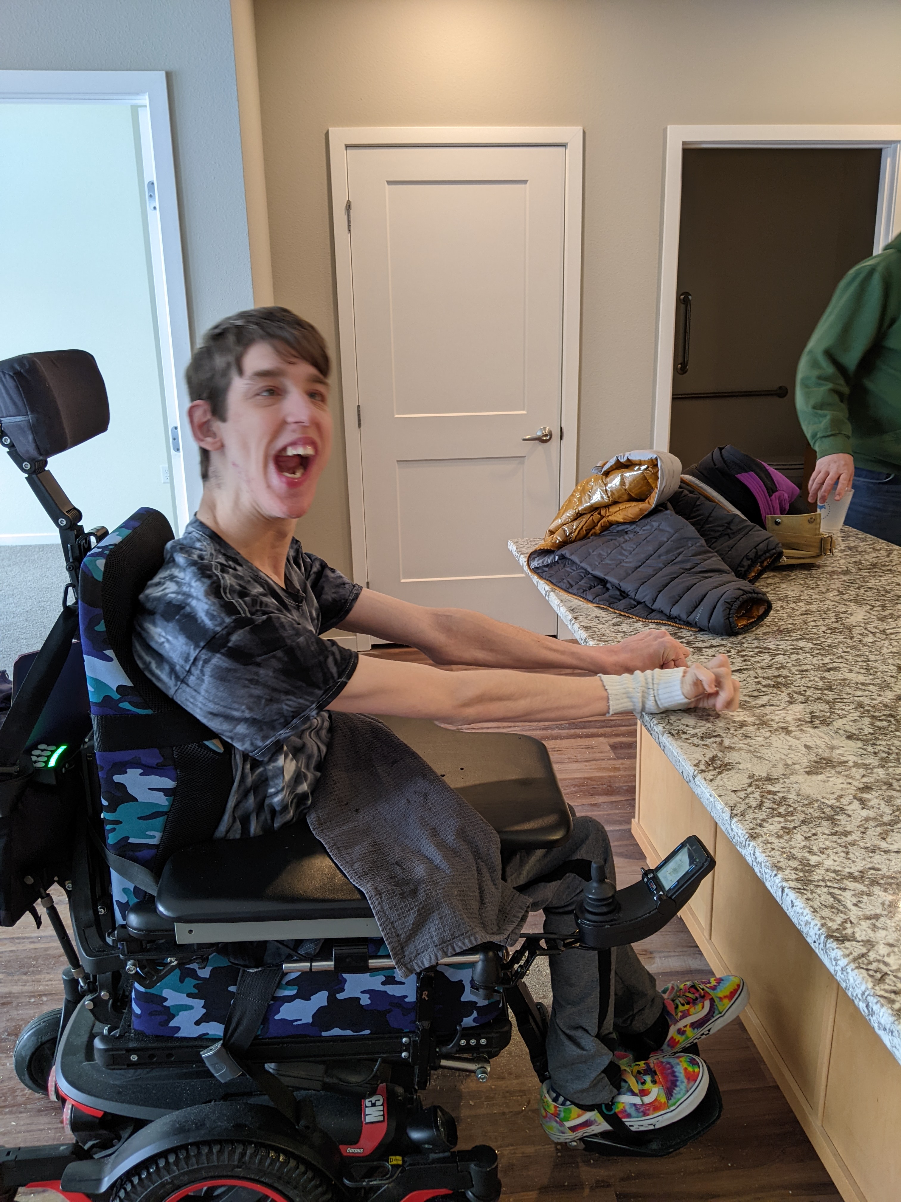 Justin in power wheelchair next to kitchen island