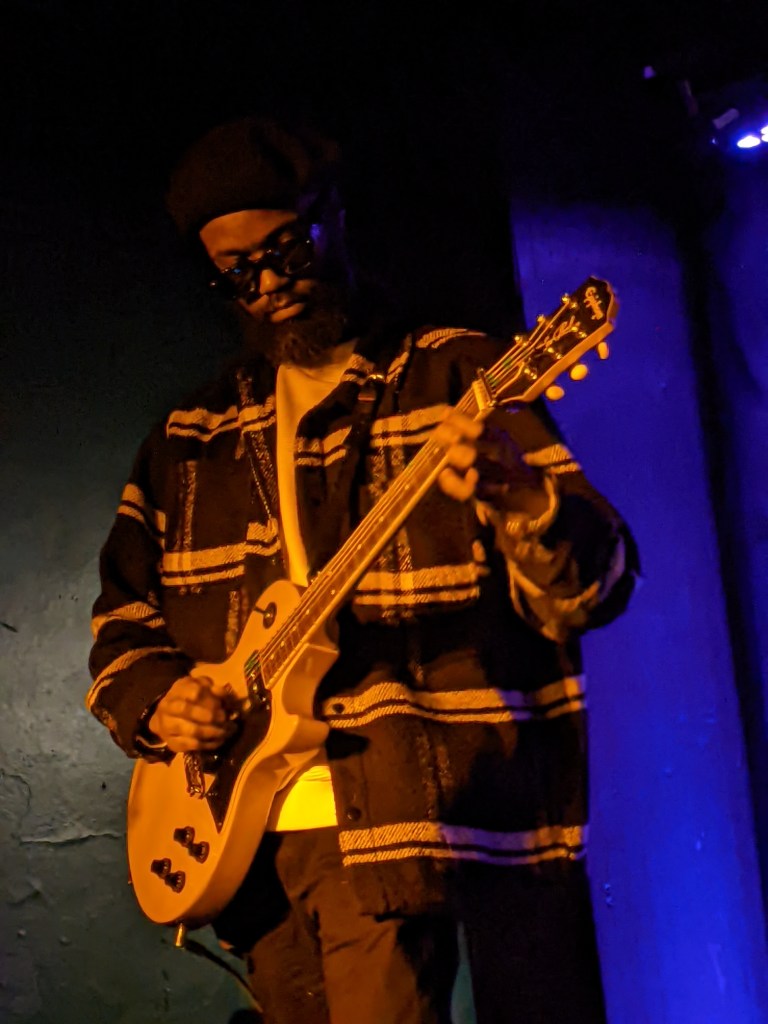 Buffalo Nichols playing guitar on stage