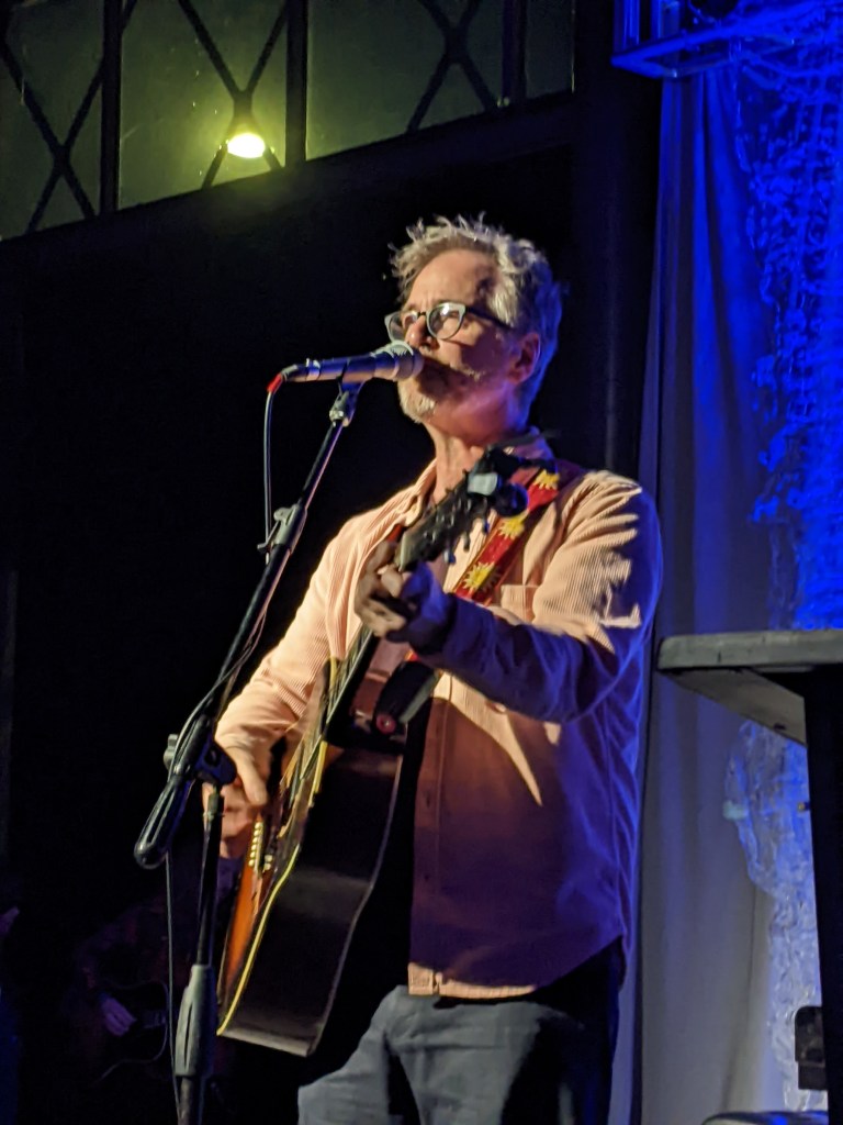 Dan Wilson singing and playing guitar on stage