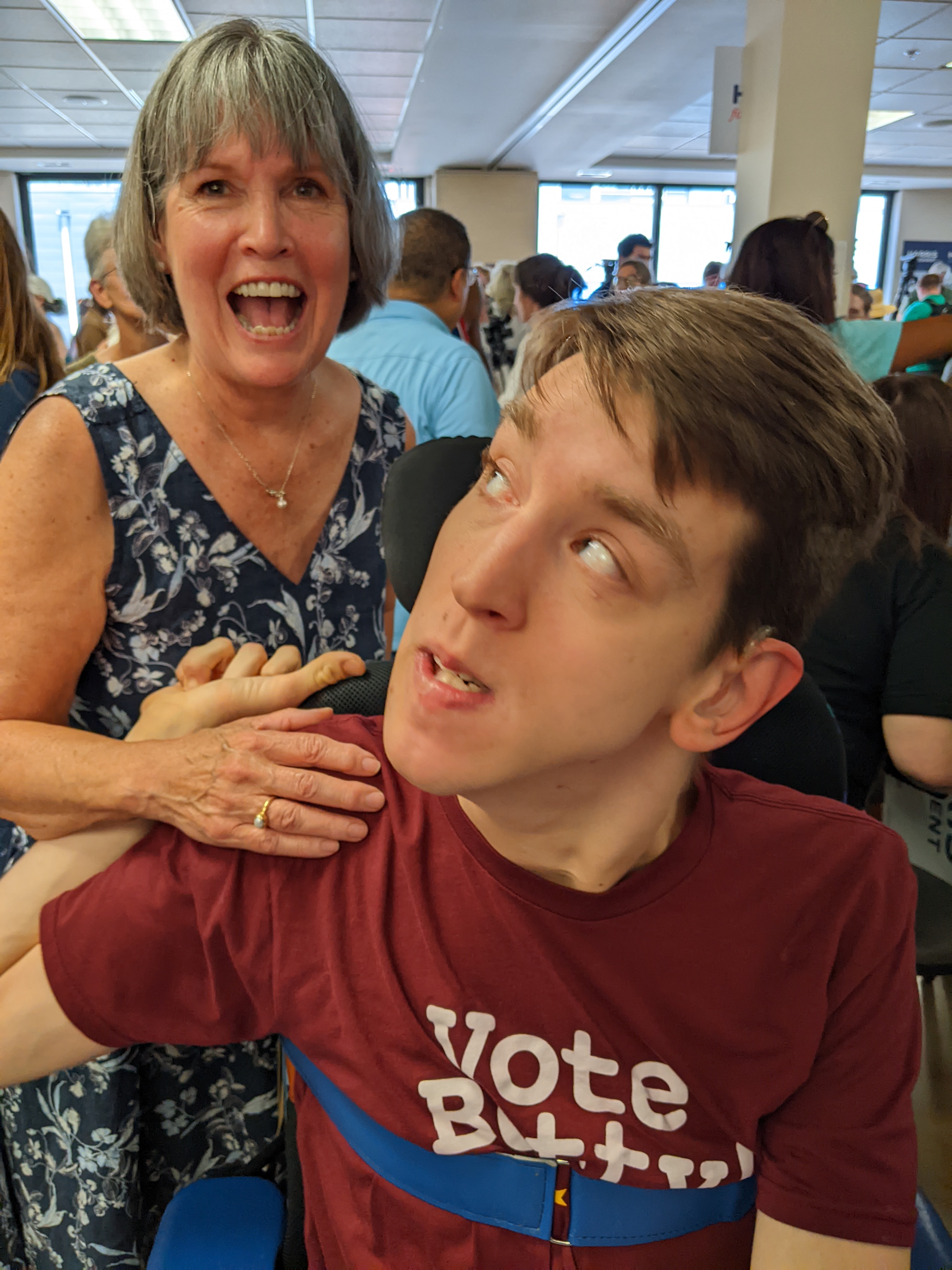 Justin looking behind him at Representative Betty McCollum, crowded room behind