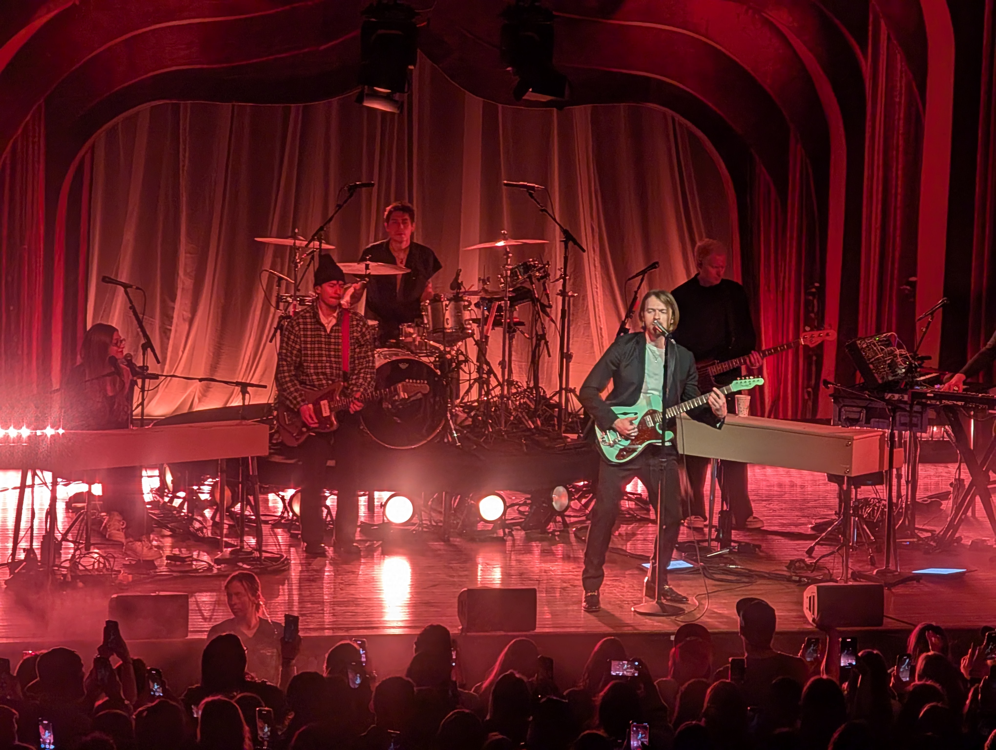 Finneas and band on stage with red lights