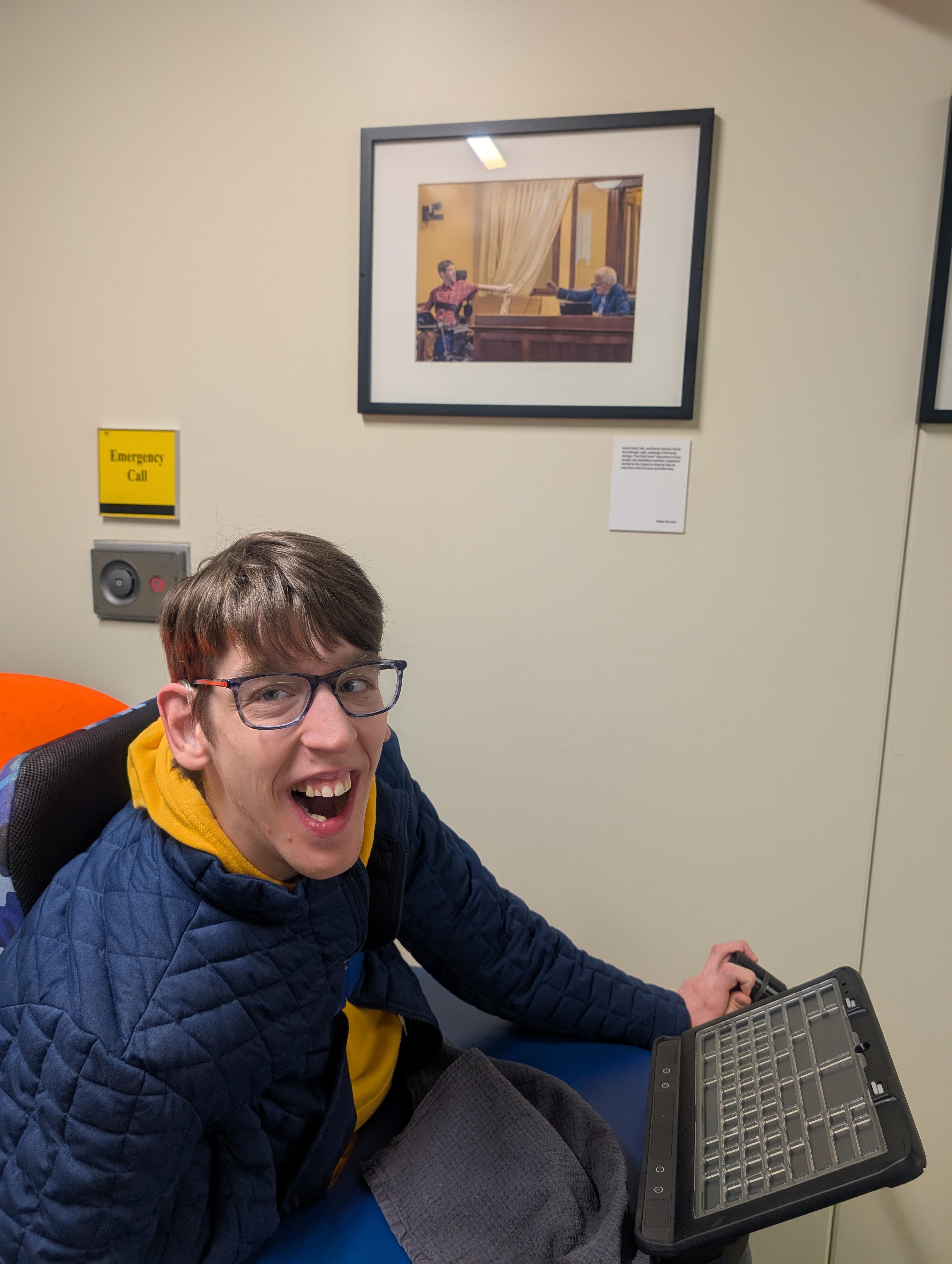 Justin in front of picture of 19-year old him giving air bump to Senator Durenberger