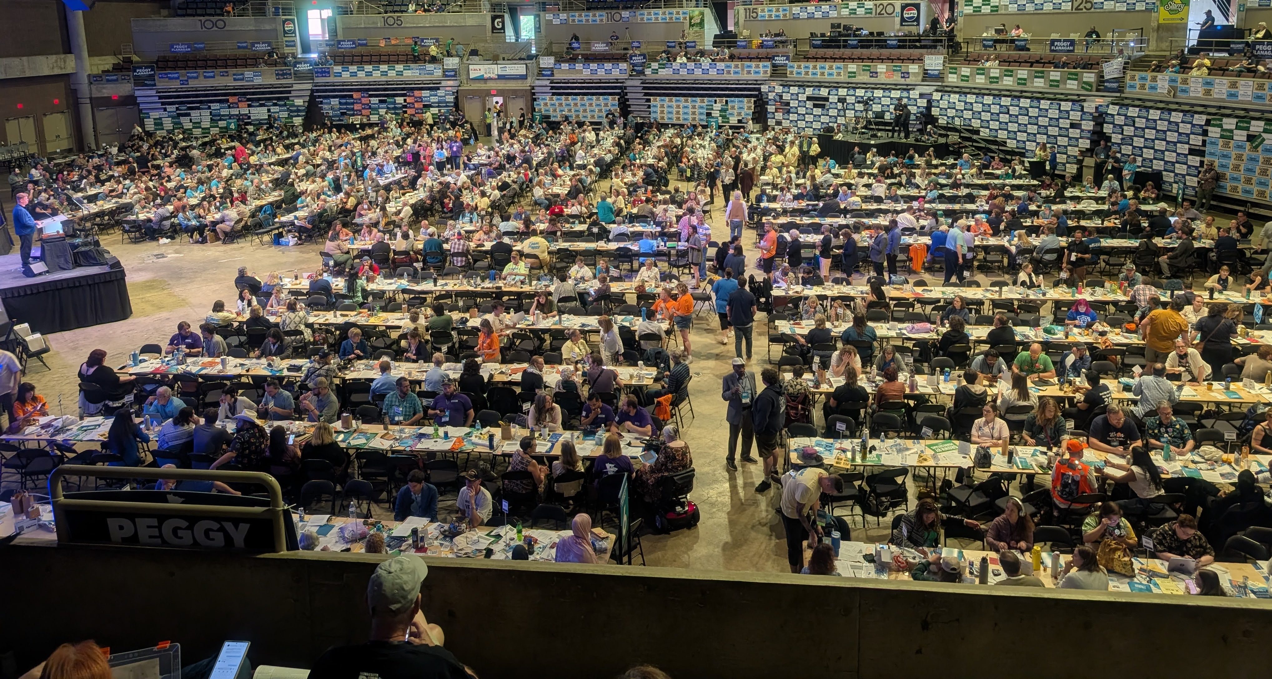Looking down at the crowded convention floor filled with tables, people, stage with podium