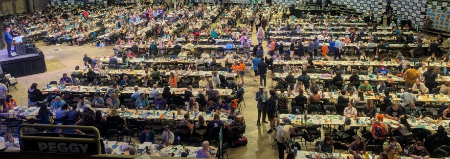 Looking down at the crowded convention floor filled with tables, people, stage with podium